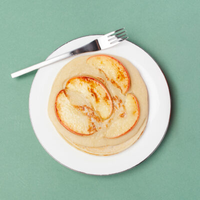 Apfel-Pfannkuchen auf einem Teller mit einer Gabel dazu