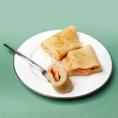 herzhafte Pfannkuchen mit Schinken und Käse liegen auf dem Teller