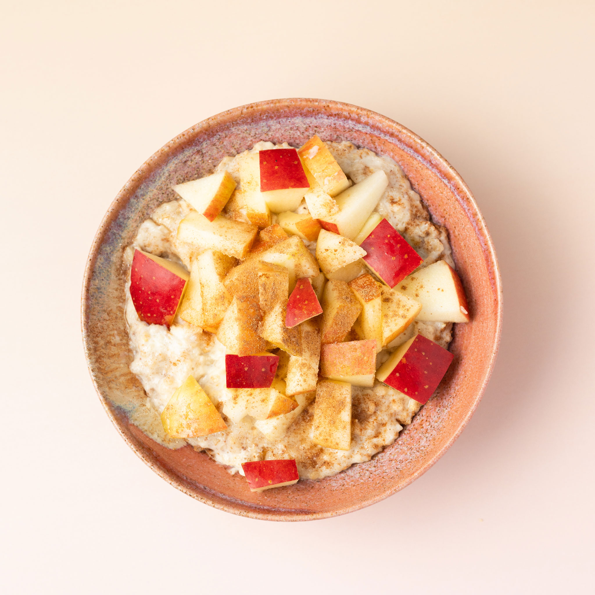 Eine rote Schüssel gefüllt mit Hafer-Brei mit Apfel