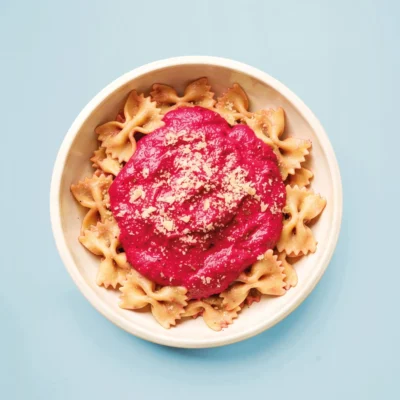 Pink Pasta auf einem weißen Teller mit blauem Hintergrund