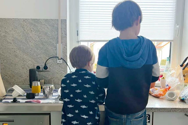 Zwei Kinder kochen zusammen Pfannkuchen